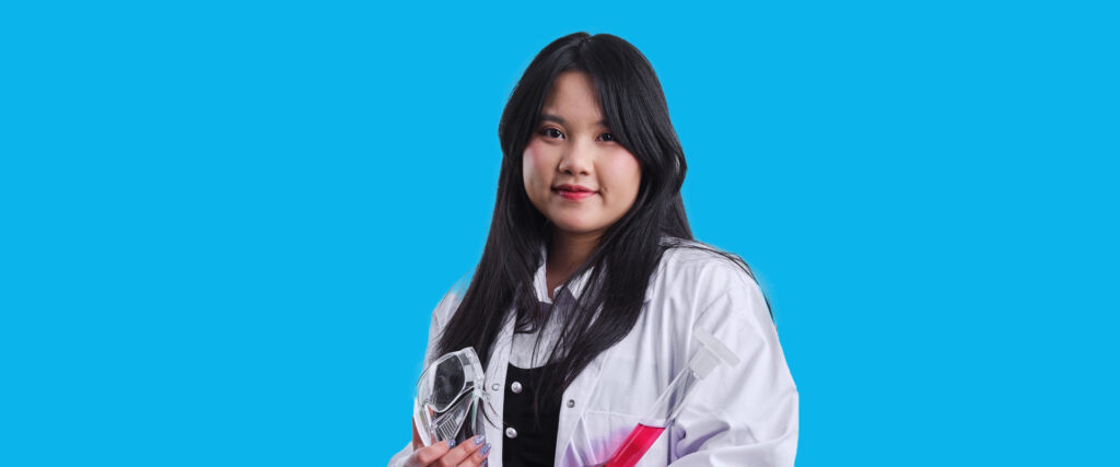 A female student of energy and environmental technology wearing a lab coat.